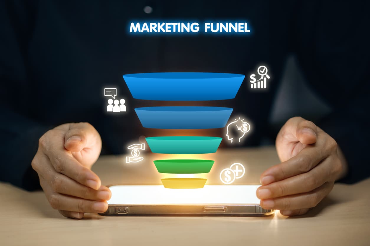 Person holding a phone displaying a colorful marketing funnel illustrating stages of a full-funnel SEO and paid media strategy